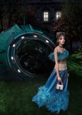 Femme élégante avec coiffure et maquillage extravagant devant une capsule spatiale verte écrasée dans un jardin sombre avec un manoir en arrière-plan. 